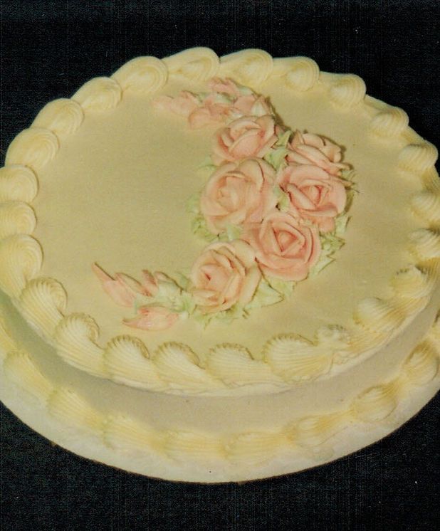 A white cake with pink roses on it