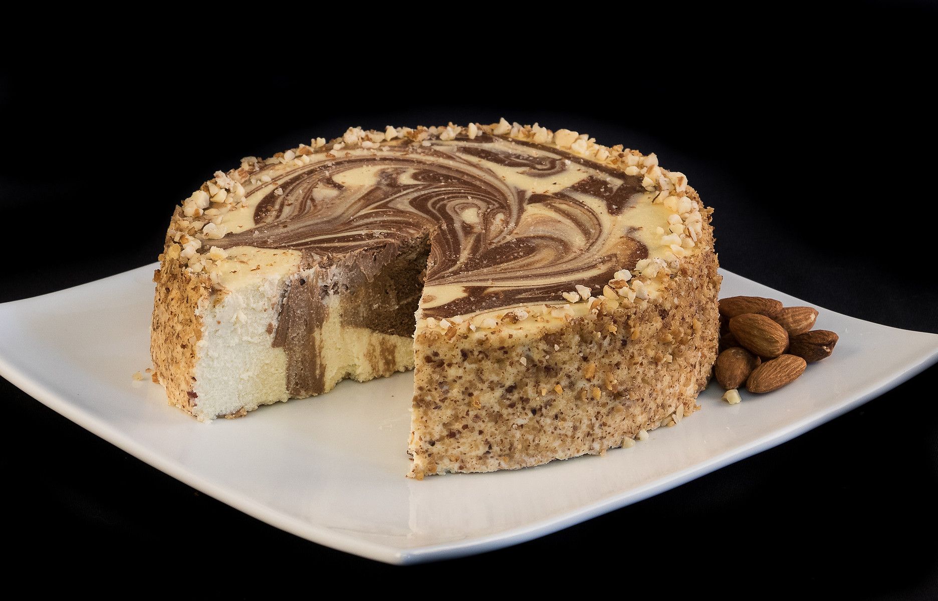 A cheesecake with a slice taken out of it is on a white plate.