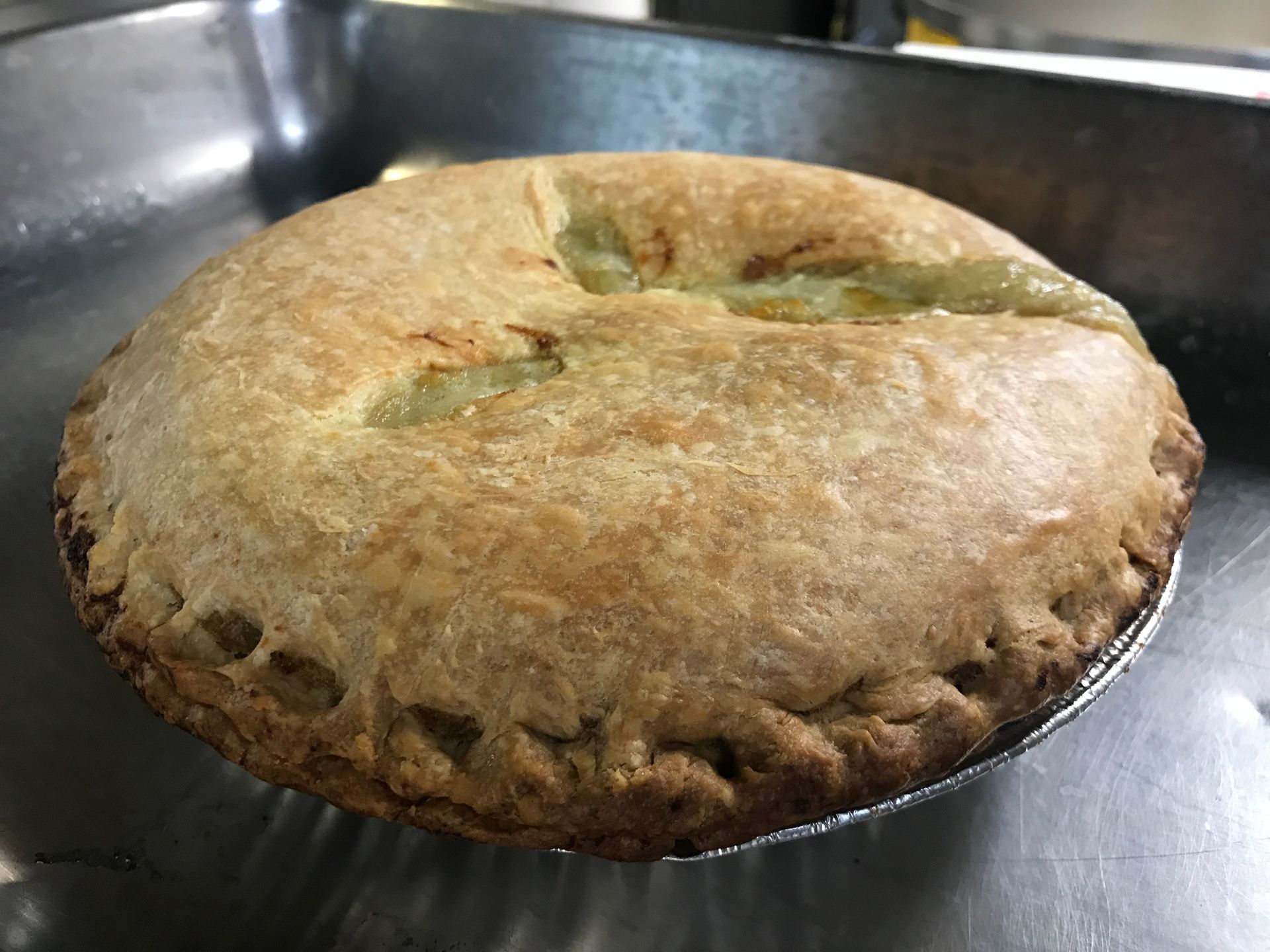 A pie is sitting on top of a metal pan.