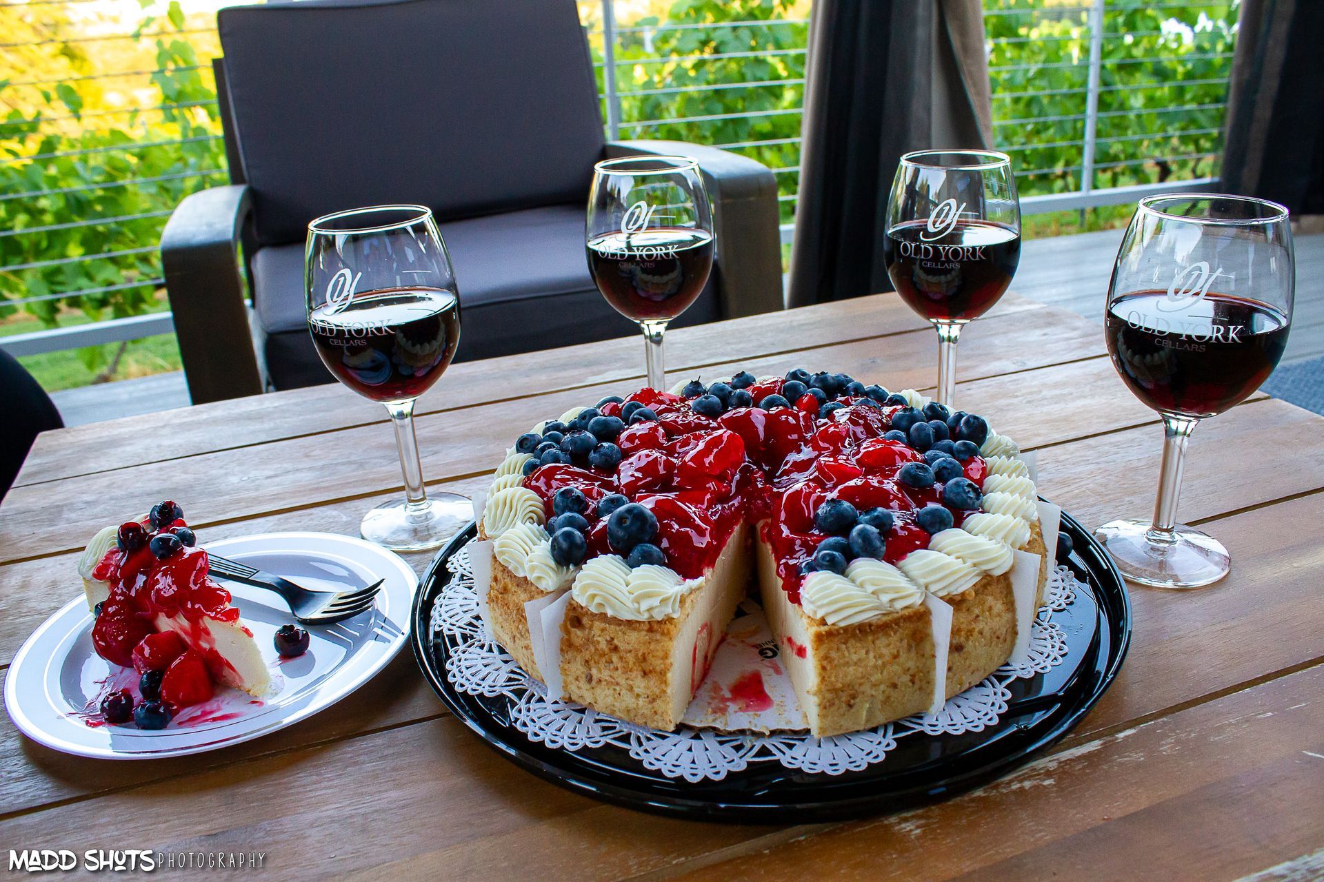 A cheesecake on a table with two glasses of wine