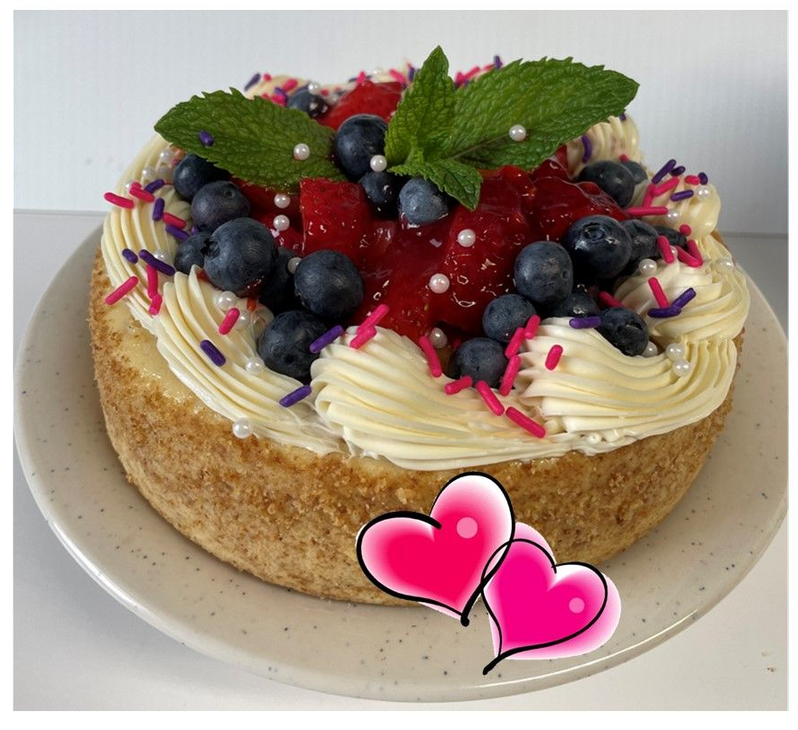 Toasted Coconut Pineapple CheeseCake Vanilla cheesecake with cream cheese icing border. fresh strawberries and blueberries