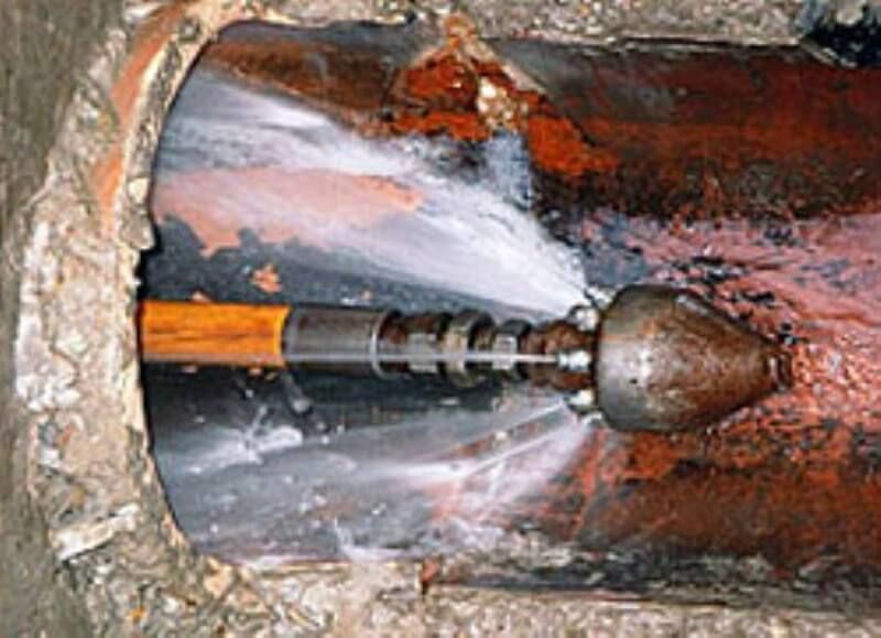 Water jet clearing pipe of blockage