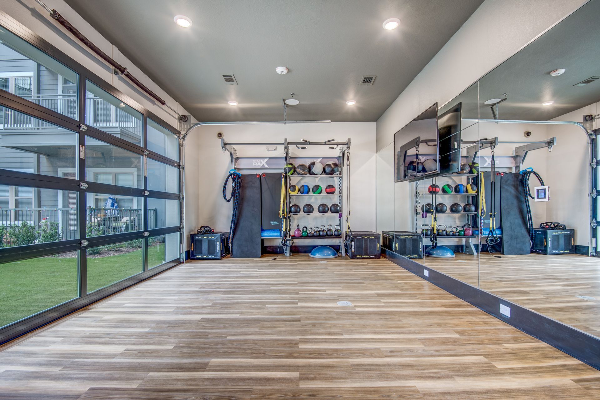 Apartment fitness center with a large mirror at Two99 Monroe offers apartments for rent in Roanoke, TX.