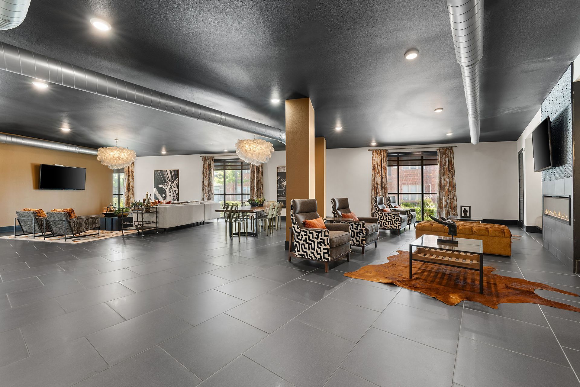 Spacious modern lobby with gray tile floors, lounge seating, wood accents, and large windows at Two99 Monroe