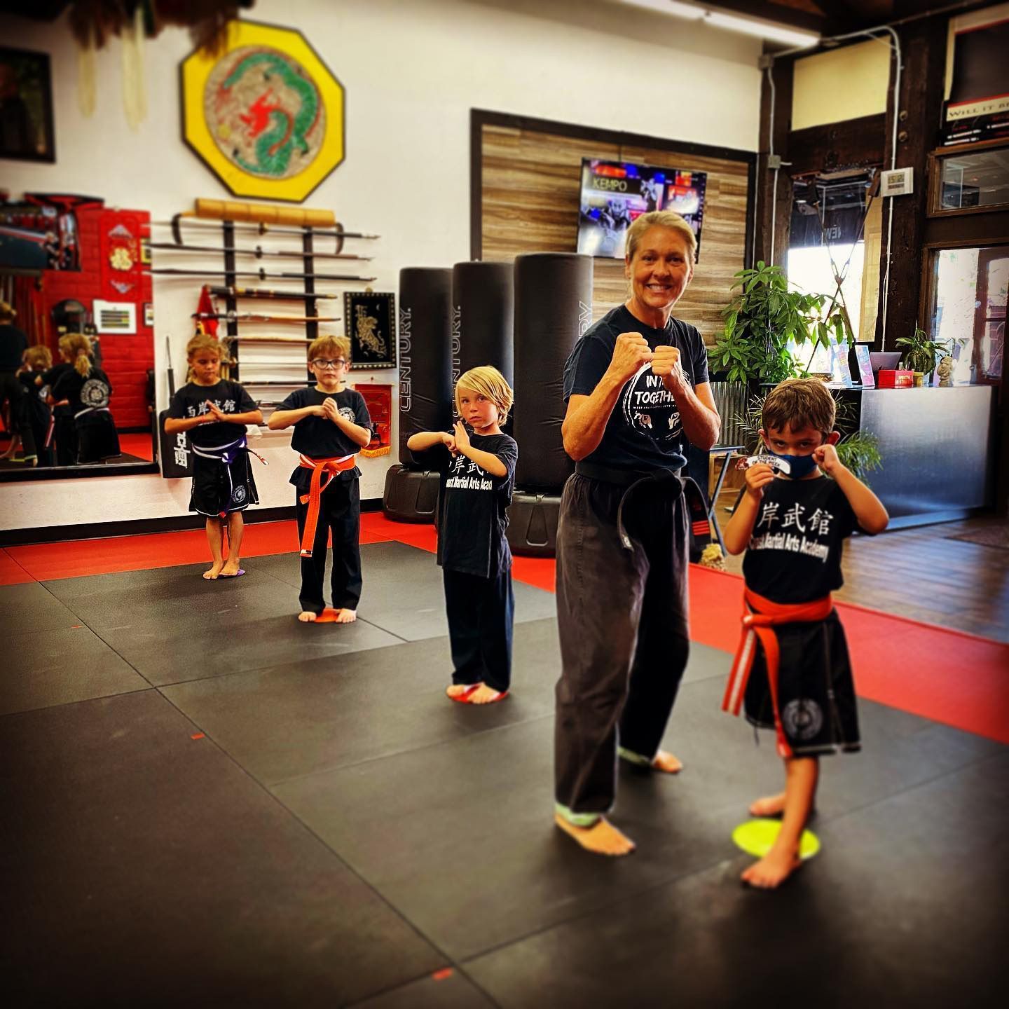 A group of children are practicing martial arts in a gym