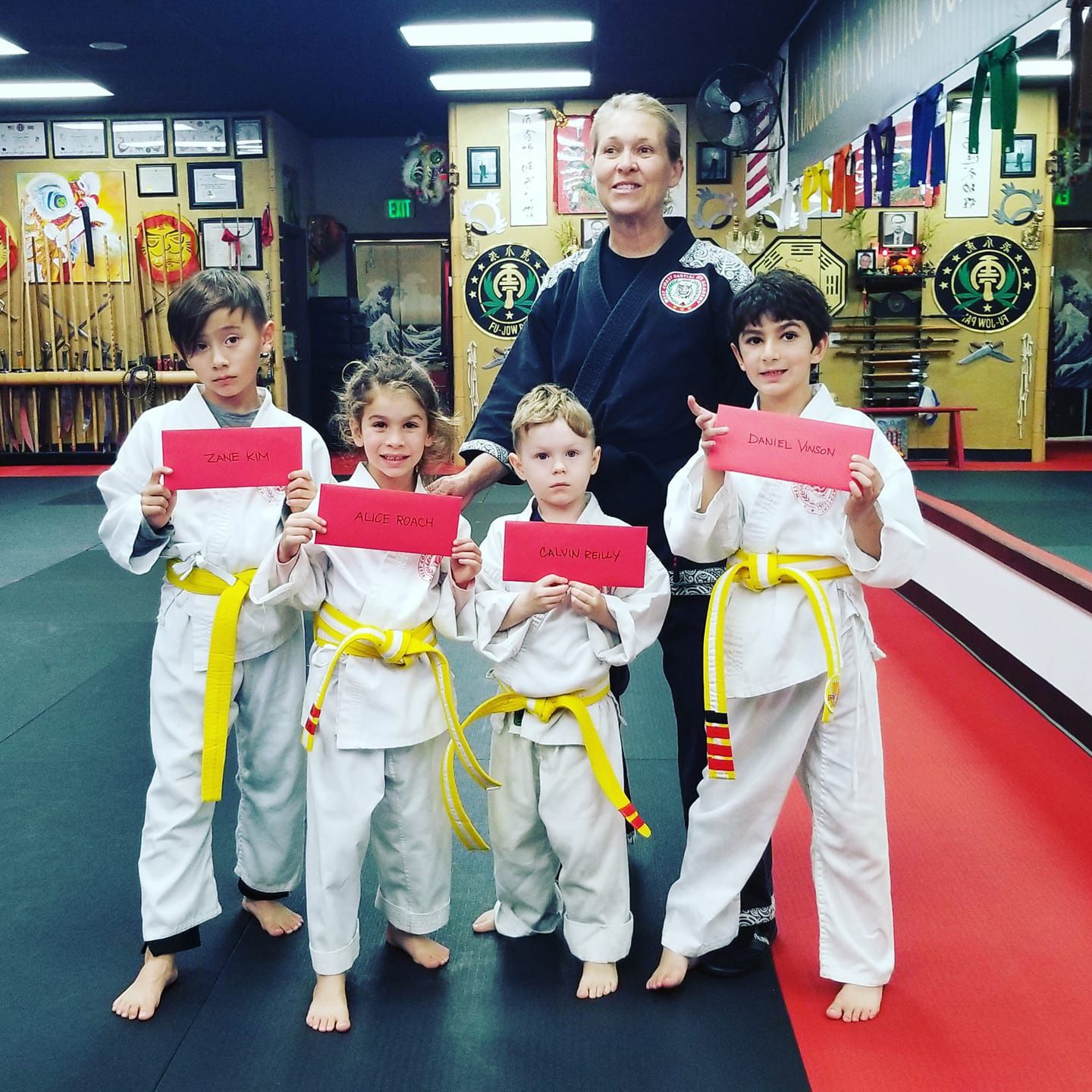 A group of kids in karate uniforms are posing for a picture