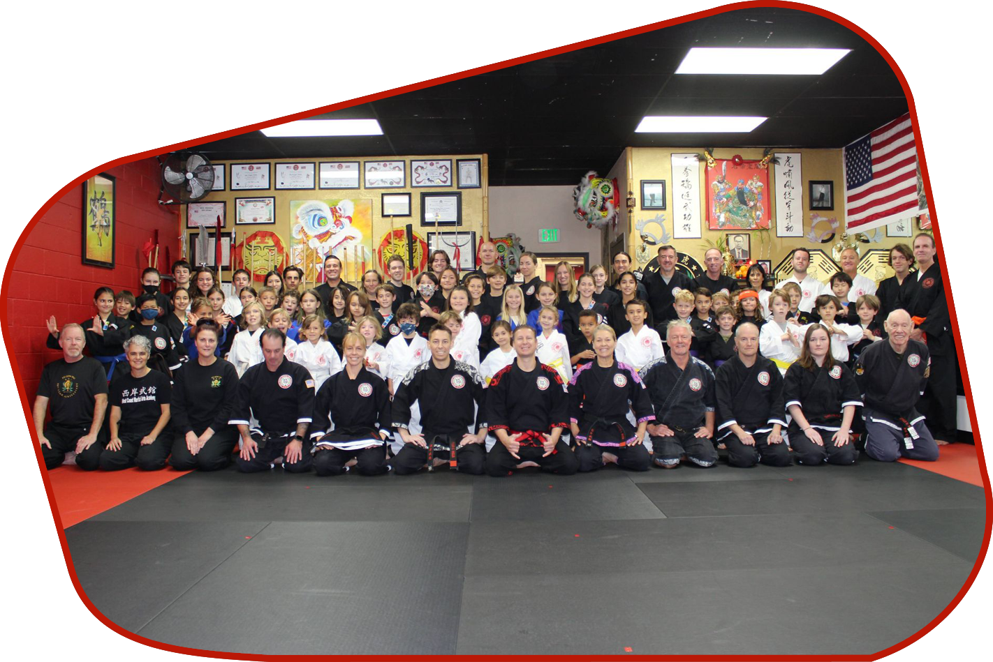A group of children are practicing martial arts in a gym.