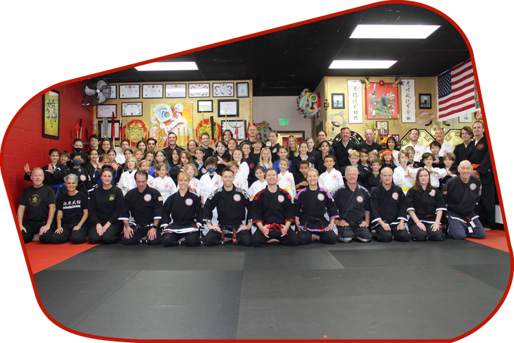 A group of children are practicing martial arts in a gym.
