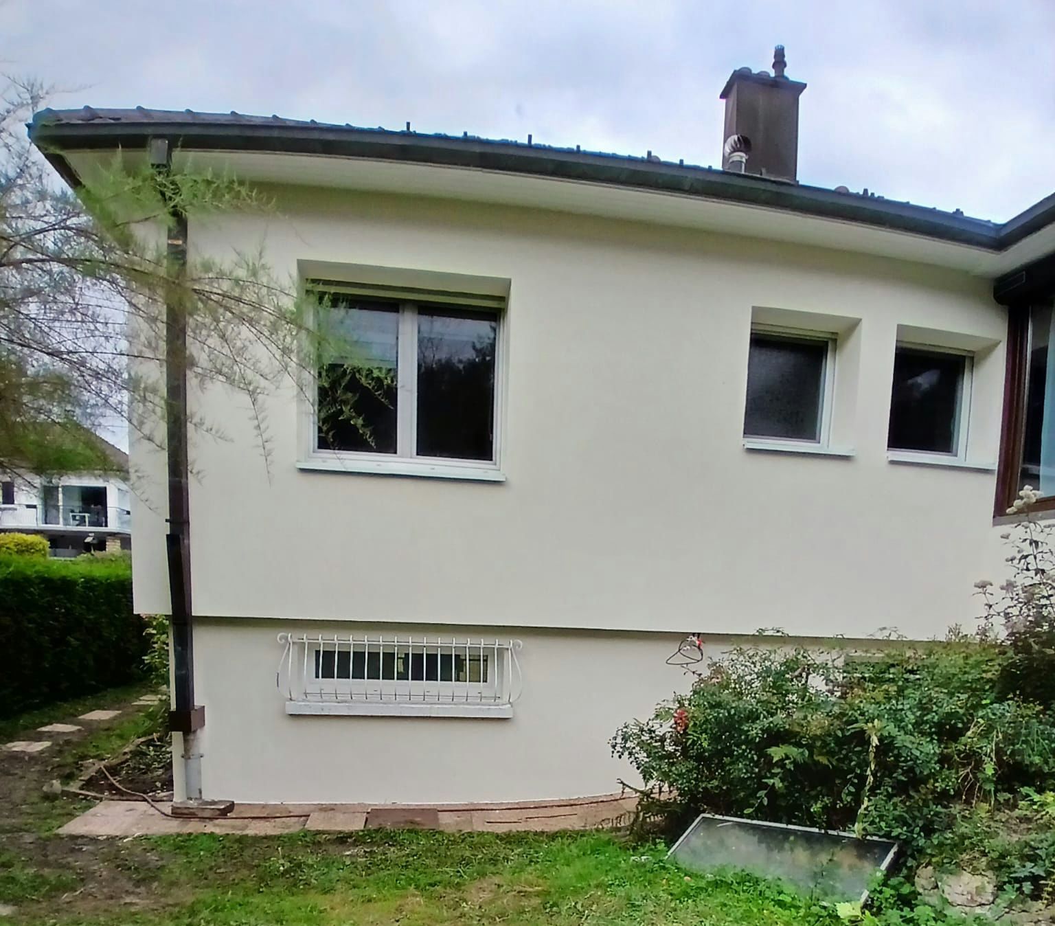 Une maison blanche avec beaucoup de fenêtres rénovée par isodeco 
