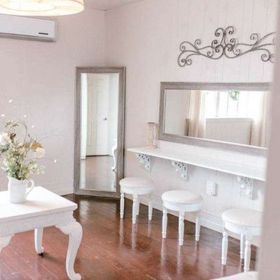 A room with a table , stools , a mirror and a mirror on the wall.