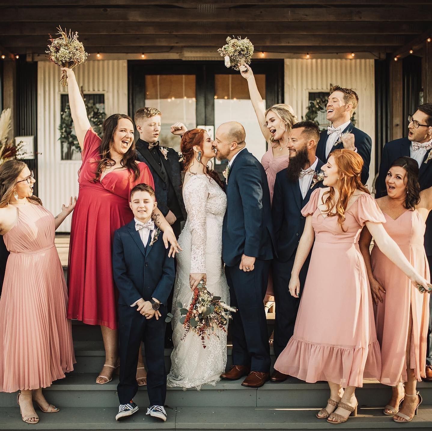 A group of people are posing for a picture at a wedding.