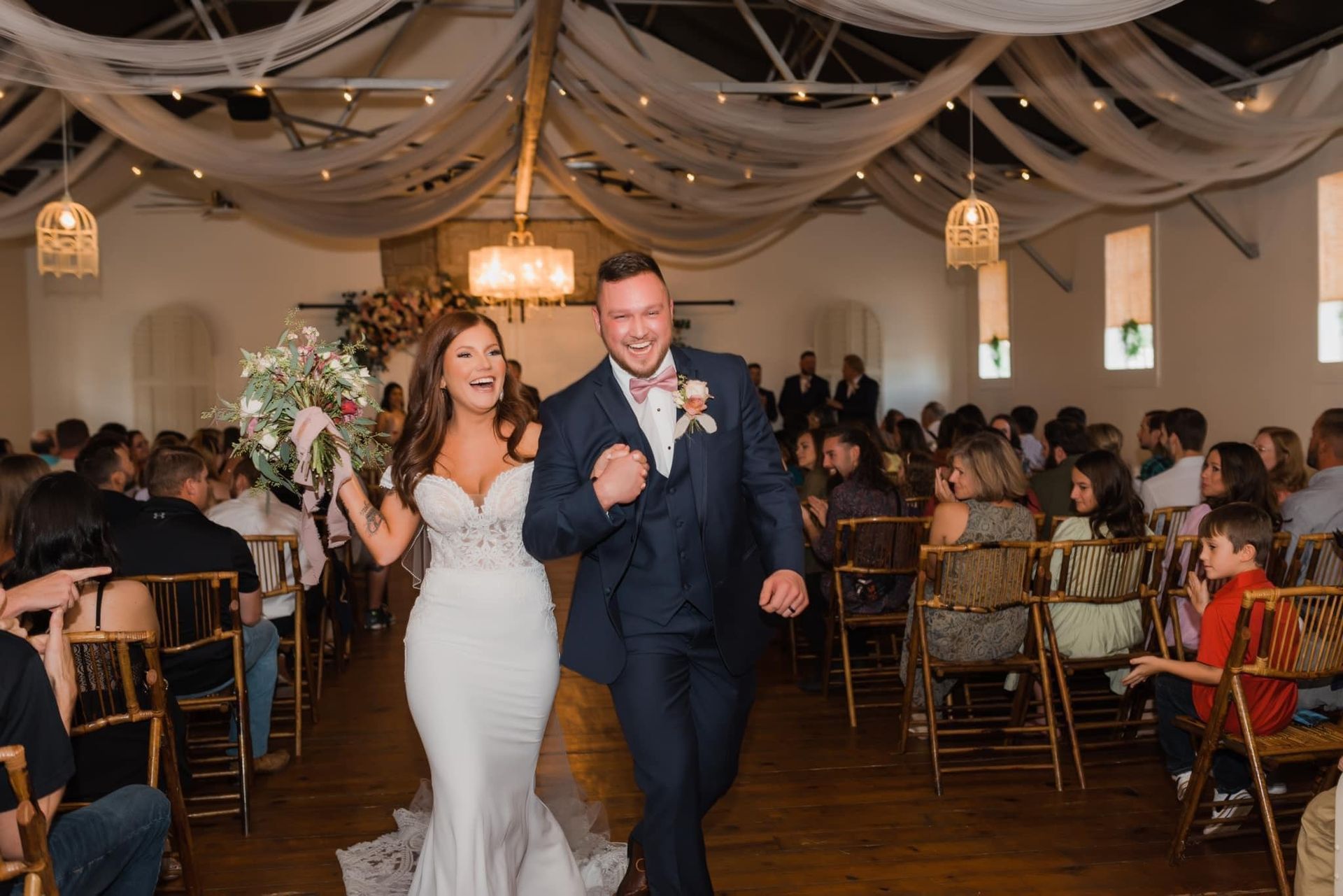 A bride and groom are walking down the aisle at their wedding.