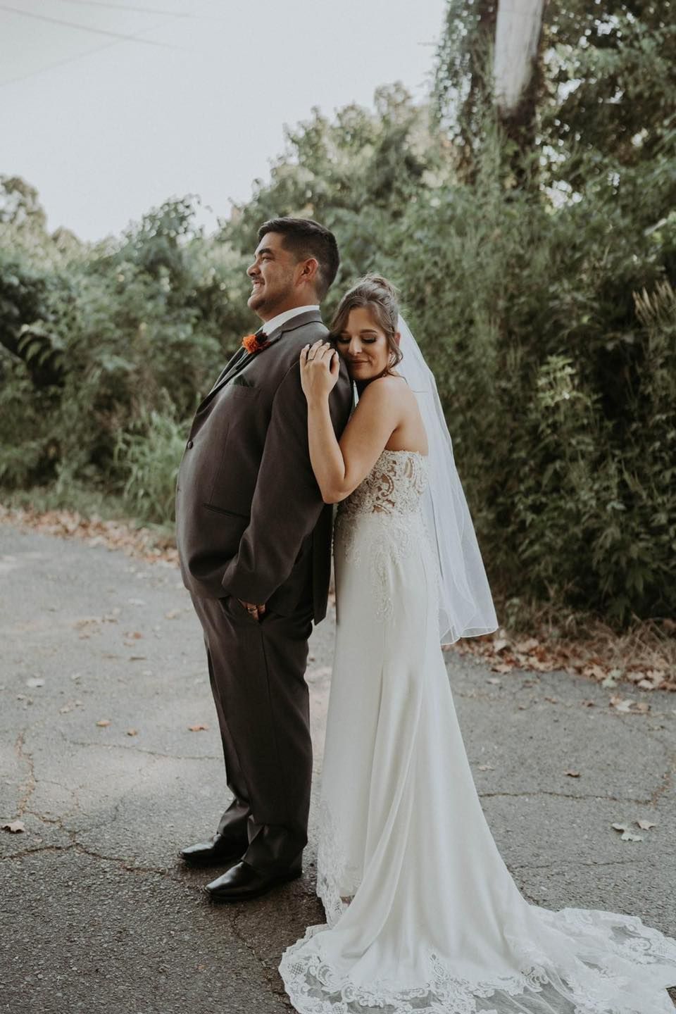A bride and groom are posing for a picture on their wedding day.