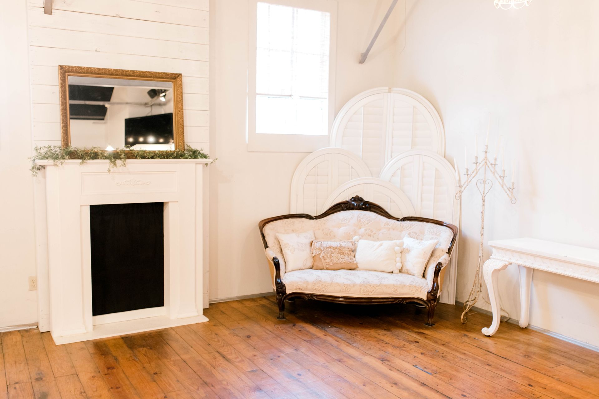 A living room with a couch , fireplace and mirror.
