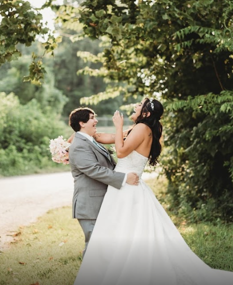 A bride and groom are dancing in front of a crowd at their wedding reception.