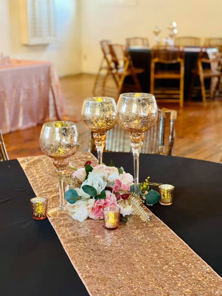 A table with two wine glasses and candles on it.