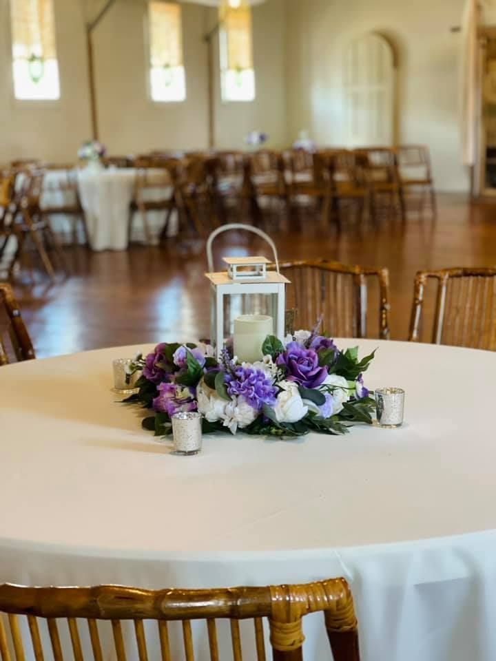 A table with flowers and candles on it in a room.