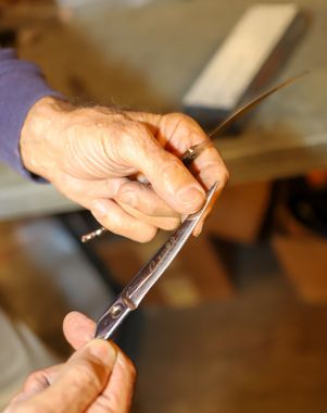 Tony owner of AJ Sales and Service holding scissors