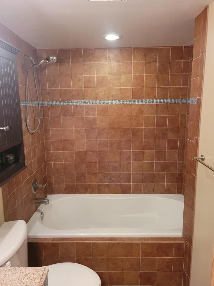 Image of a bathroom that is getting a tile refinishing job done. You can see the floor is being prepped to install the tiles. 