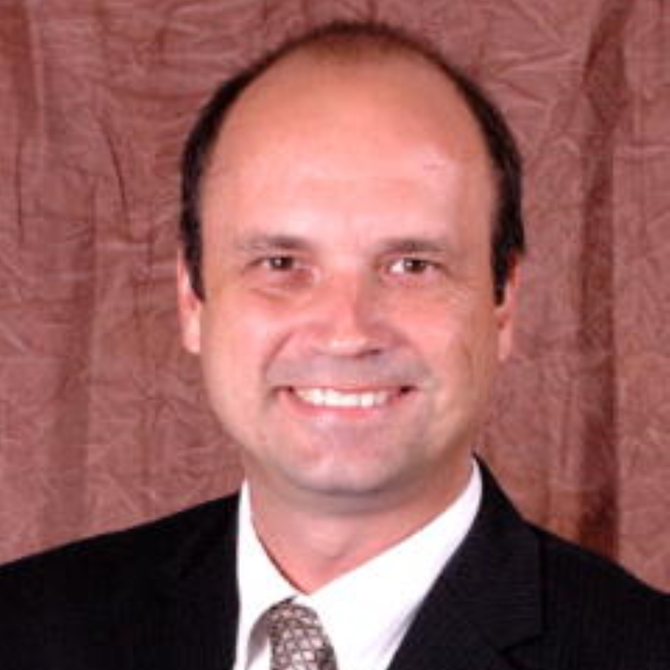 A man in a suit and tie smiles for the camera