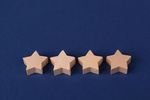 Four beige star-shaped wooden blocks on a blue background