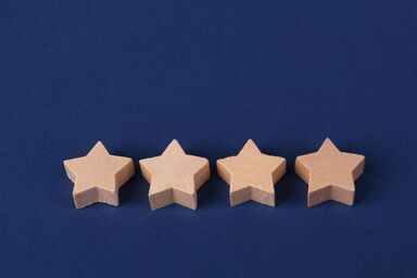 Four beige star-shaped wooden blocks on a blue background