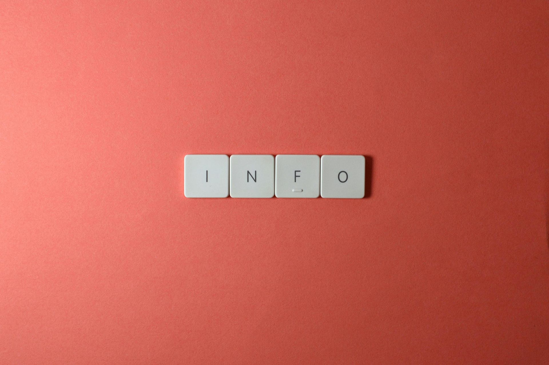 The word "info" spelled out in scrabble letters is laid out on a table