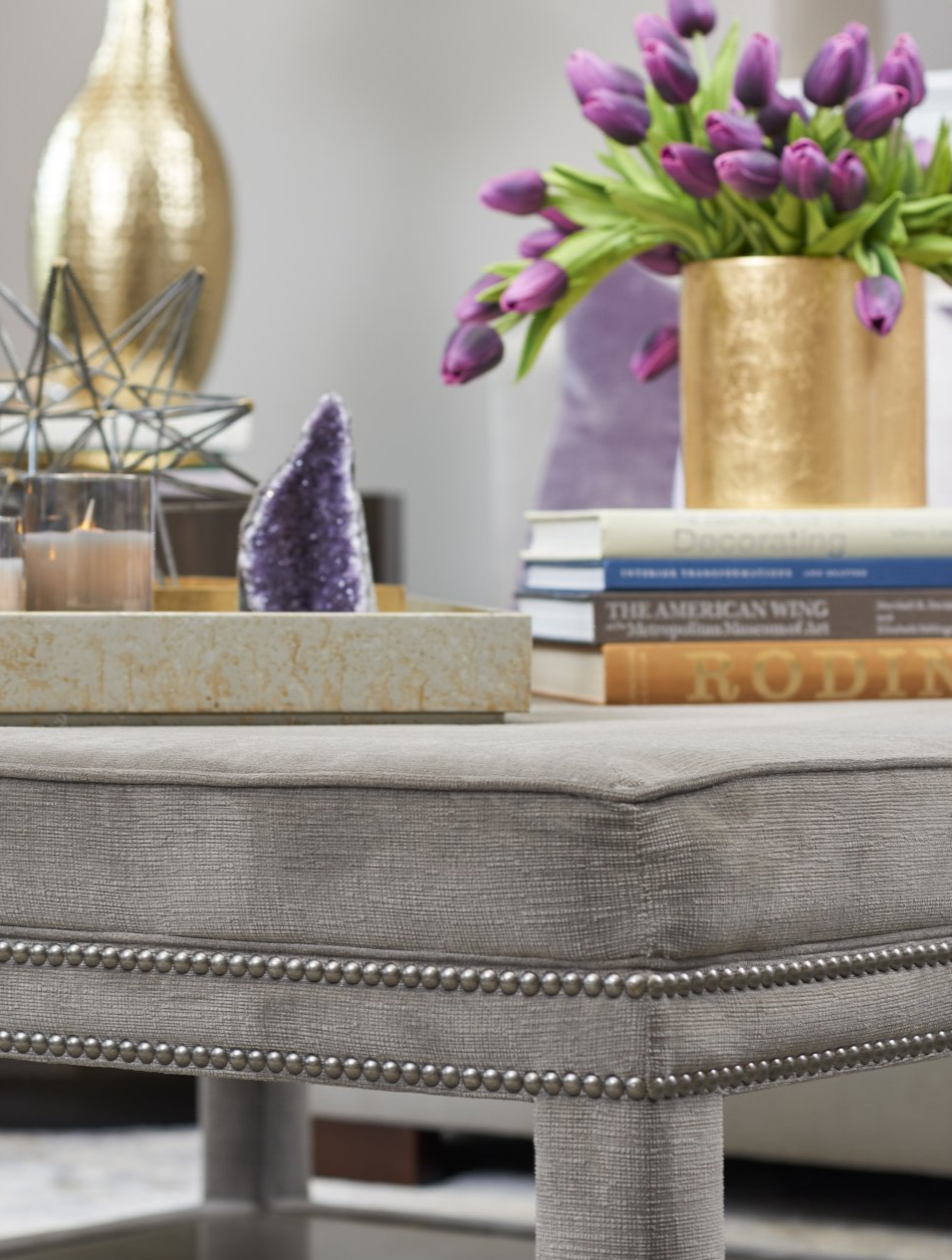 A table with a vase of purple flowers and books on it