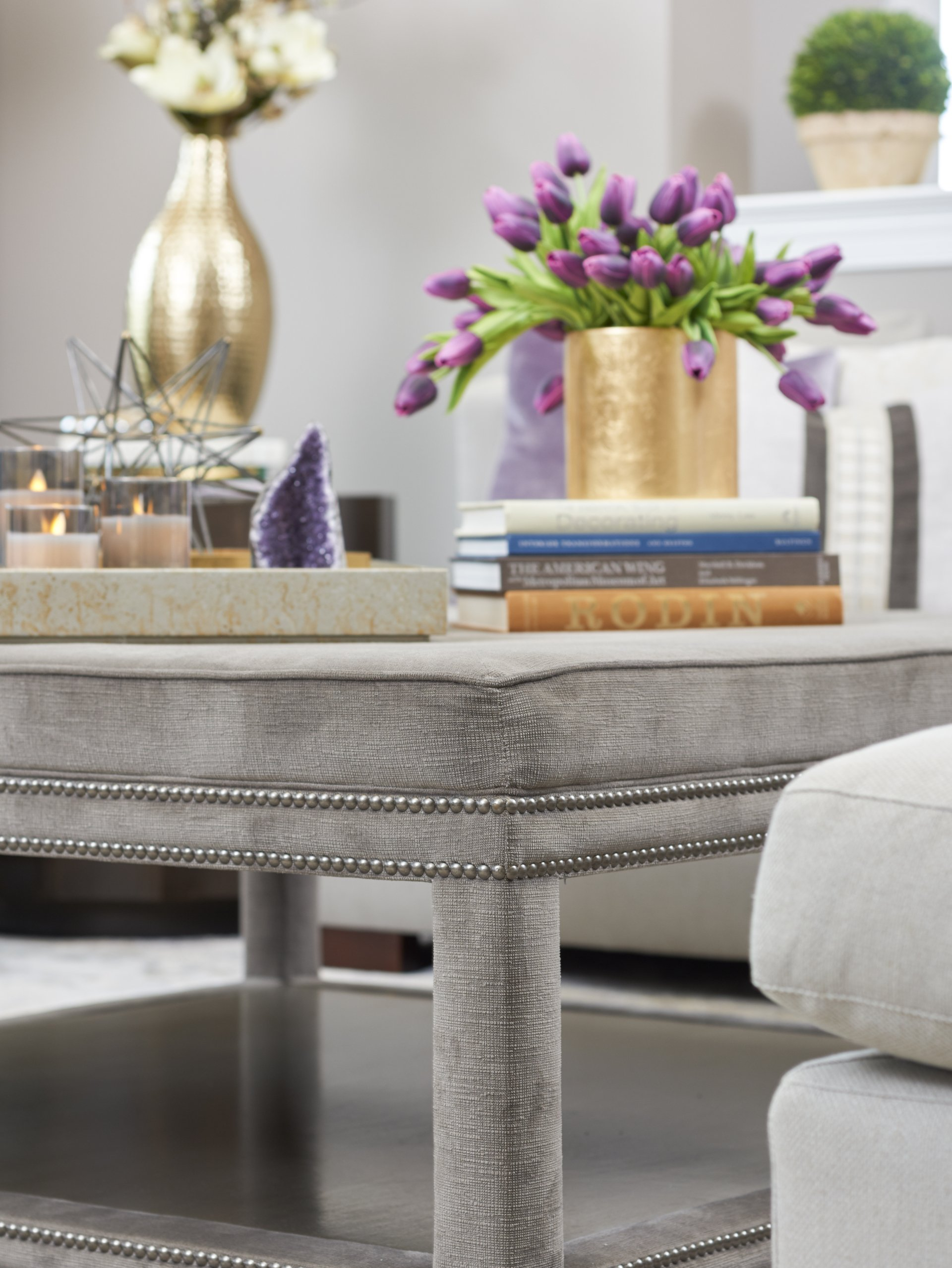 A coffee table with a vase of purple flowers on it