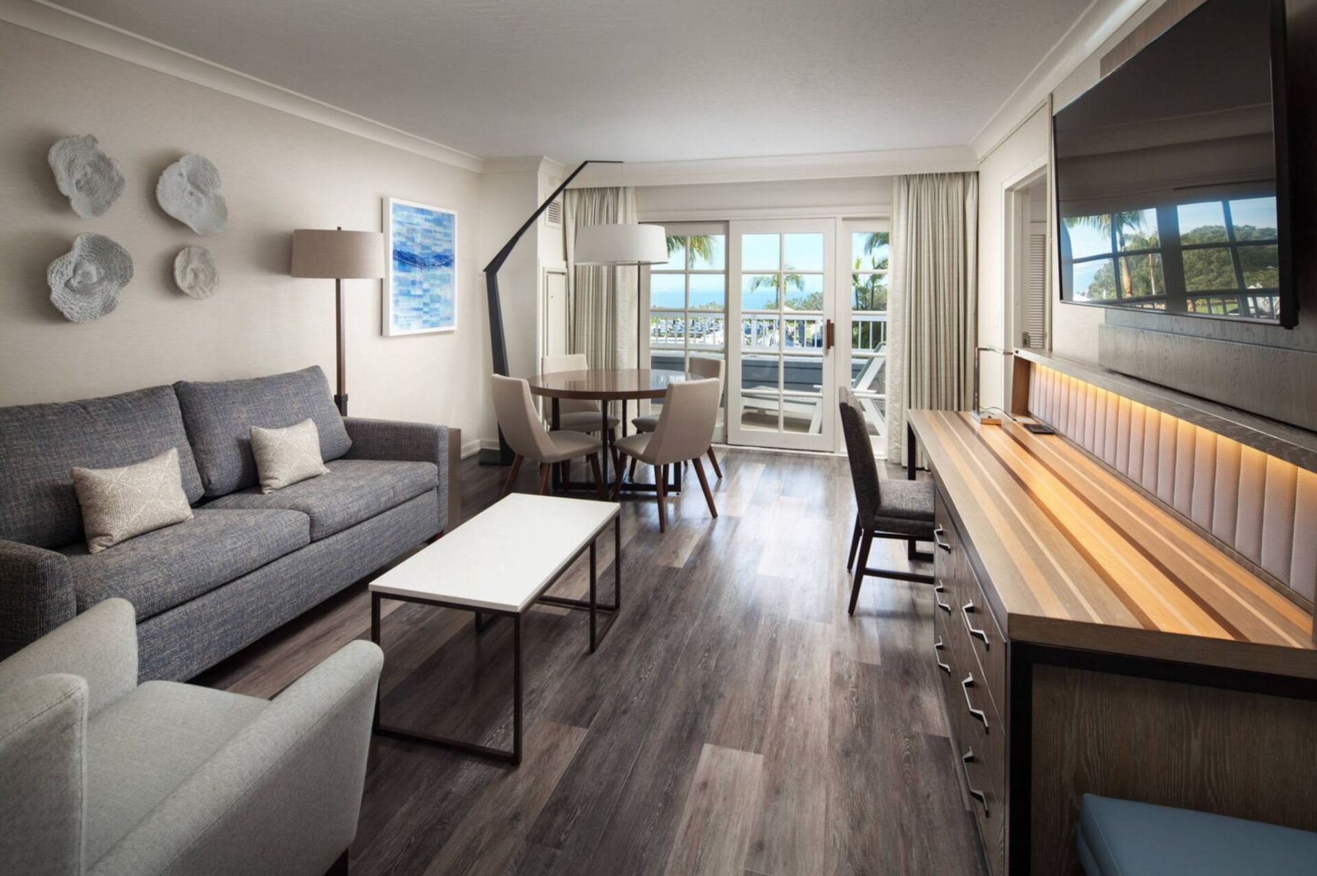 A living room with a couch , chairs , table and television.