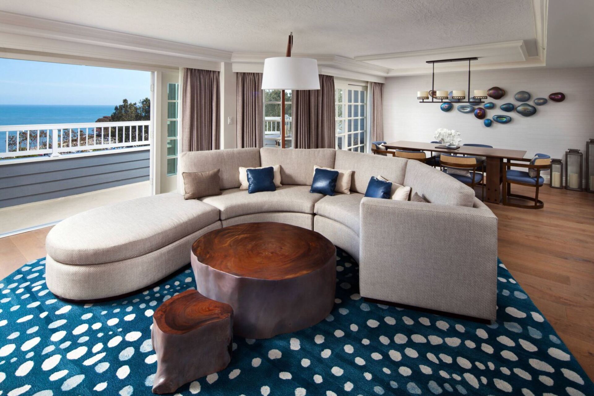 A living room with a couch and a table with a view of the ocean.
