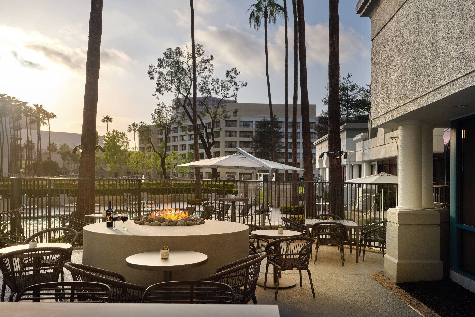 A patio with tables and chairs and a fire pit