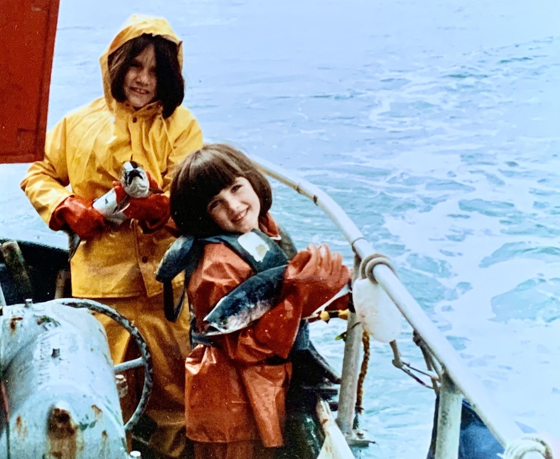 group of people on a fishing boat, 2 are dancing whole 1 plays guitar