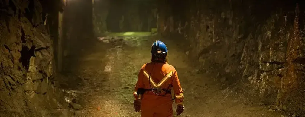 Miner standing in a mine shaft assess dilution control