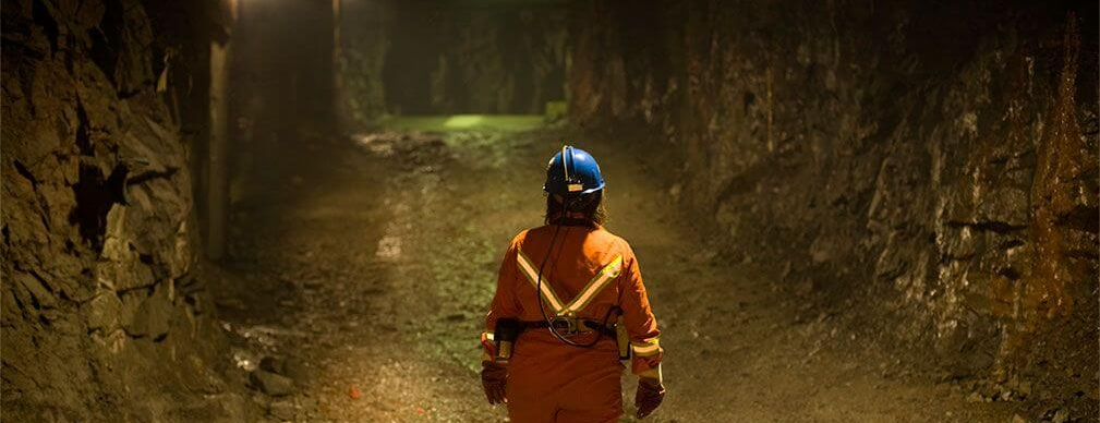 Miner standing in a mine shaft assess dilution control