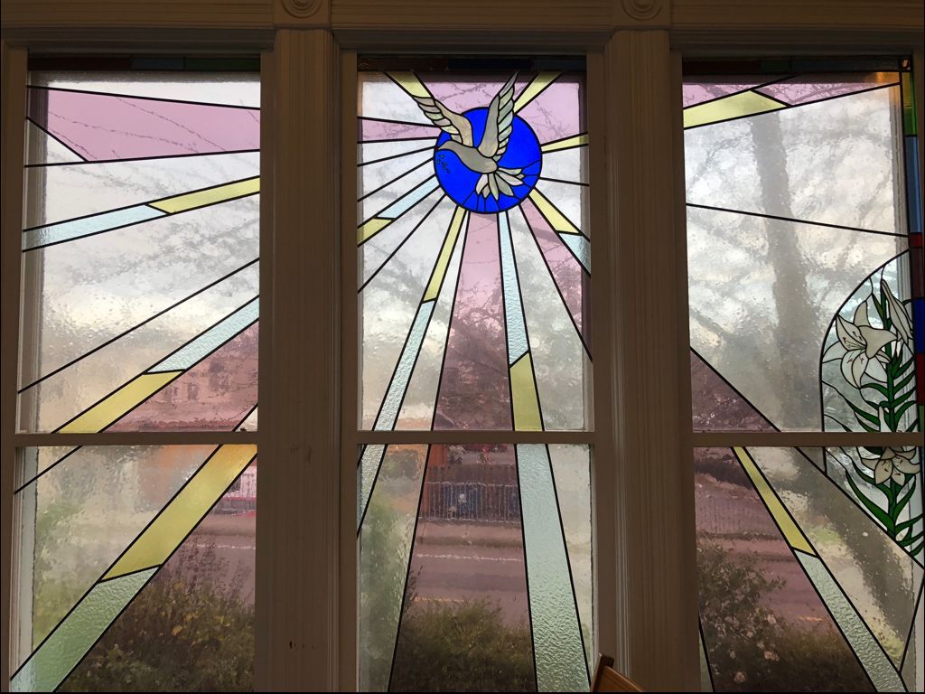 A stained glass window with a dove on it