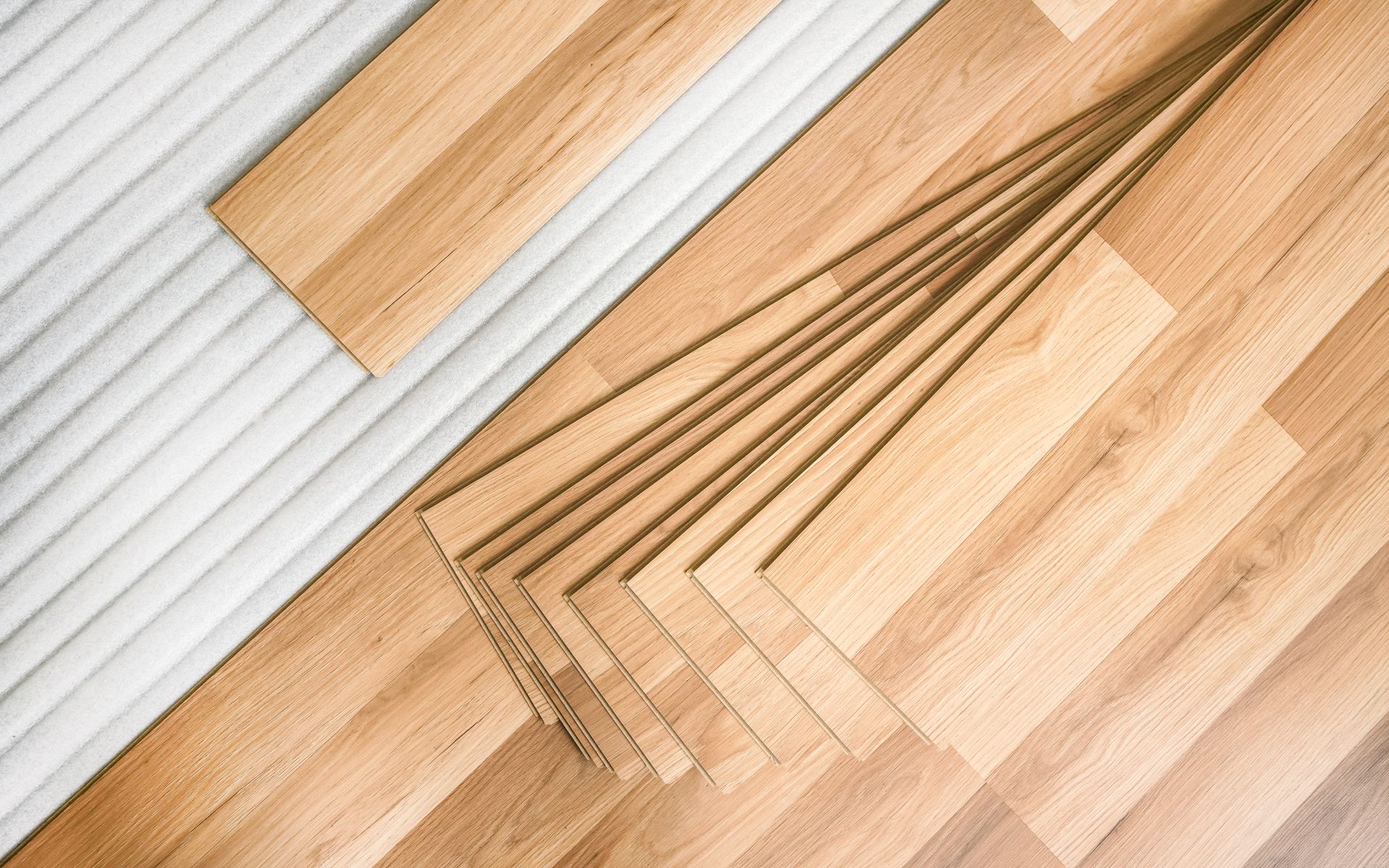A stack of wooden flooring sitting on top of a wooden floor.