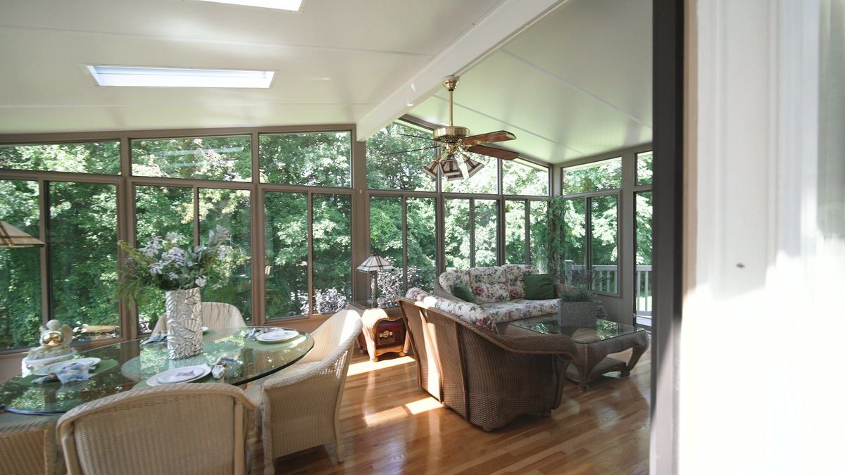 Sunroom windows surround a seating area