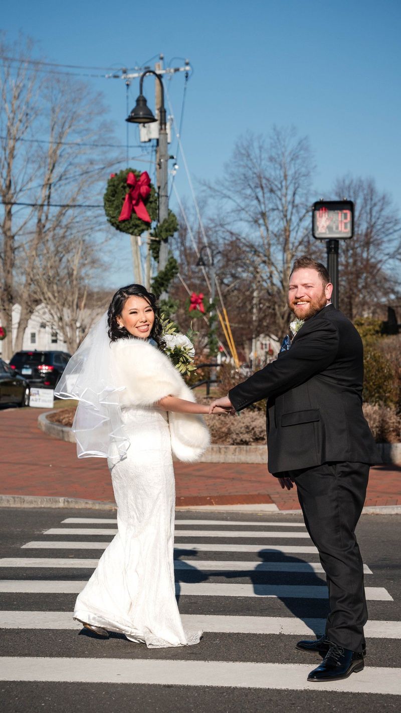 Amanda and Charles hold hands on a striped crosswalk
