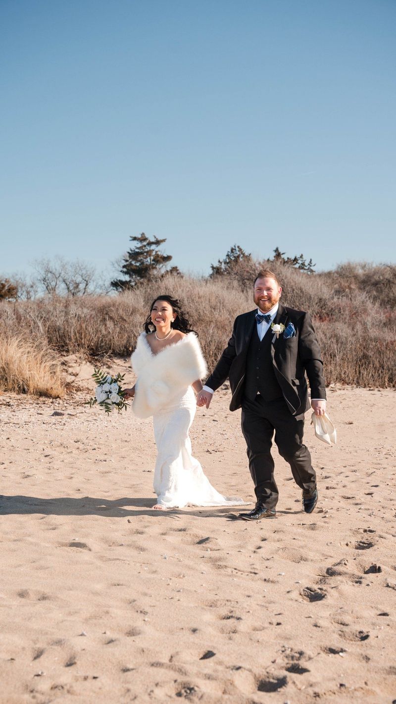 Amanda and Charles walk hand in hand across the sand