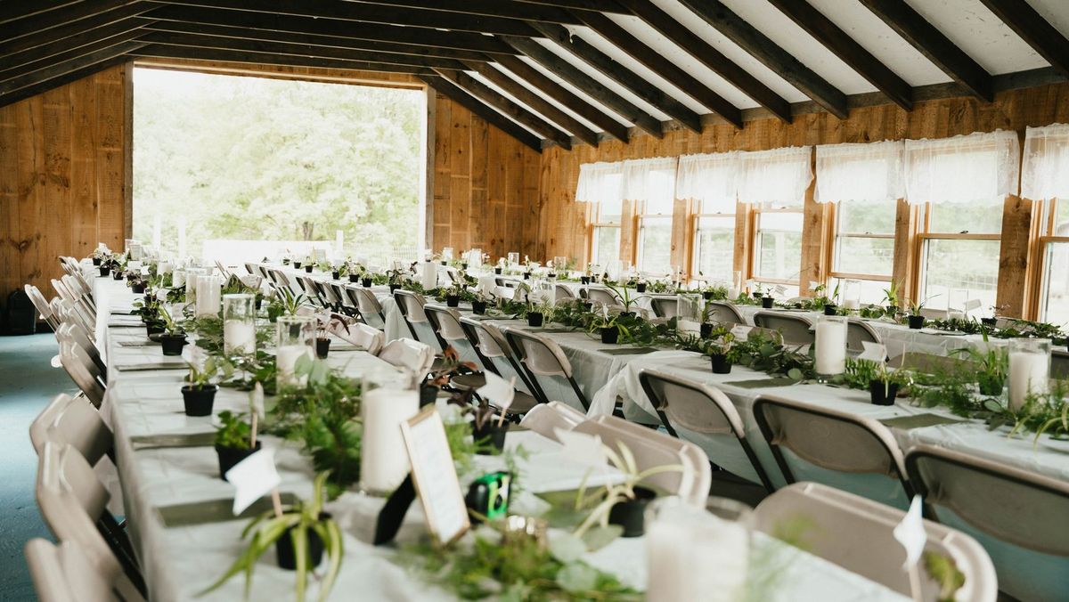 Reception tables set inside the wooden farm building