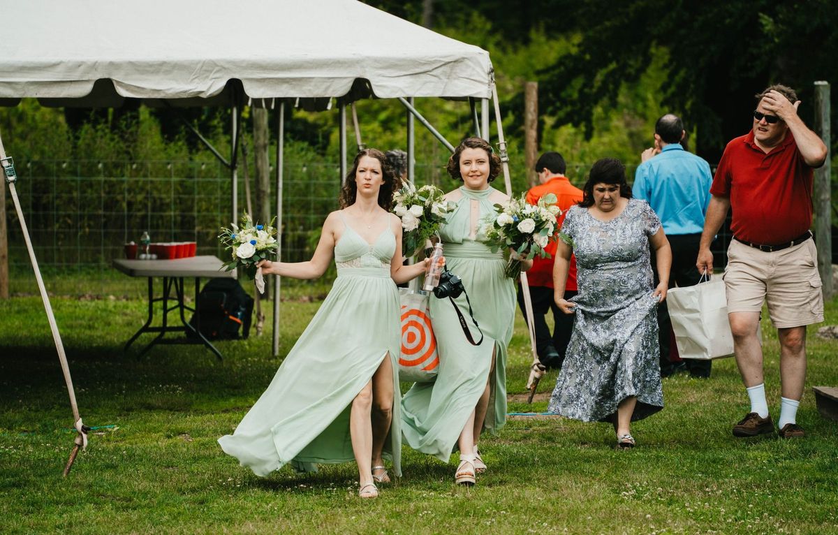 Ashley walks across the lawn carrying her bouquet
