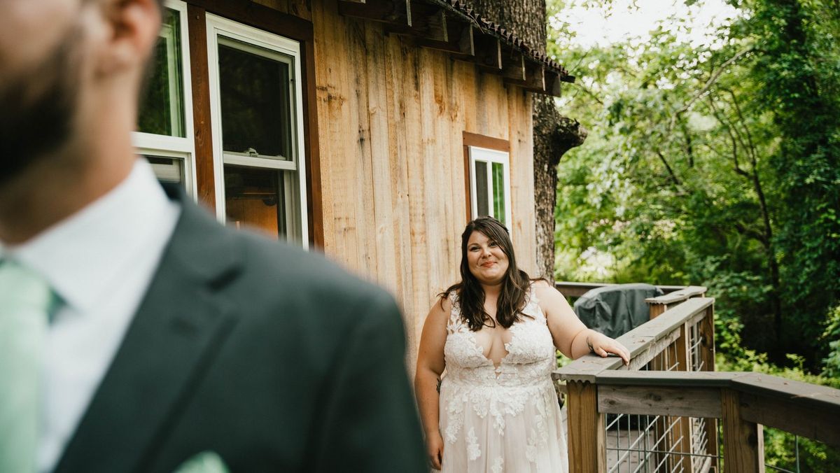 Ashley approaches Anthony from behind on the wooden deck for their first look