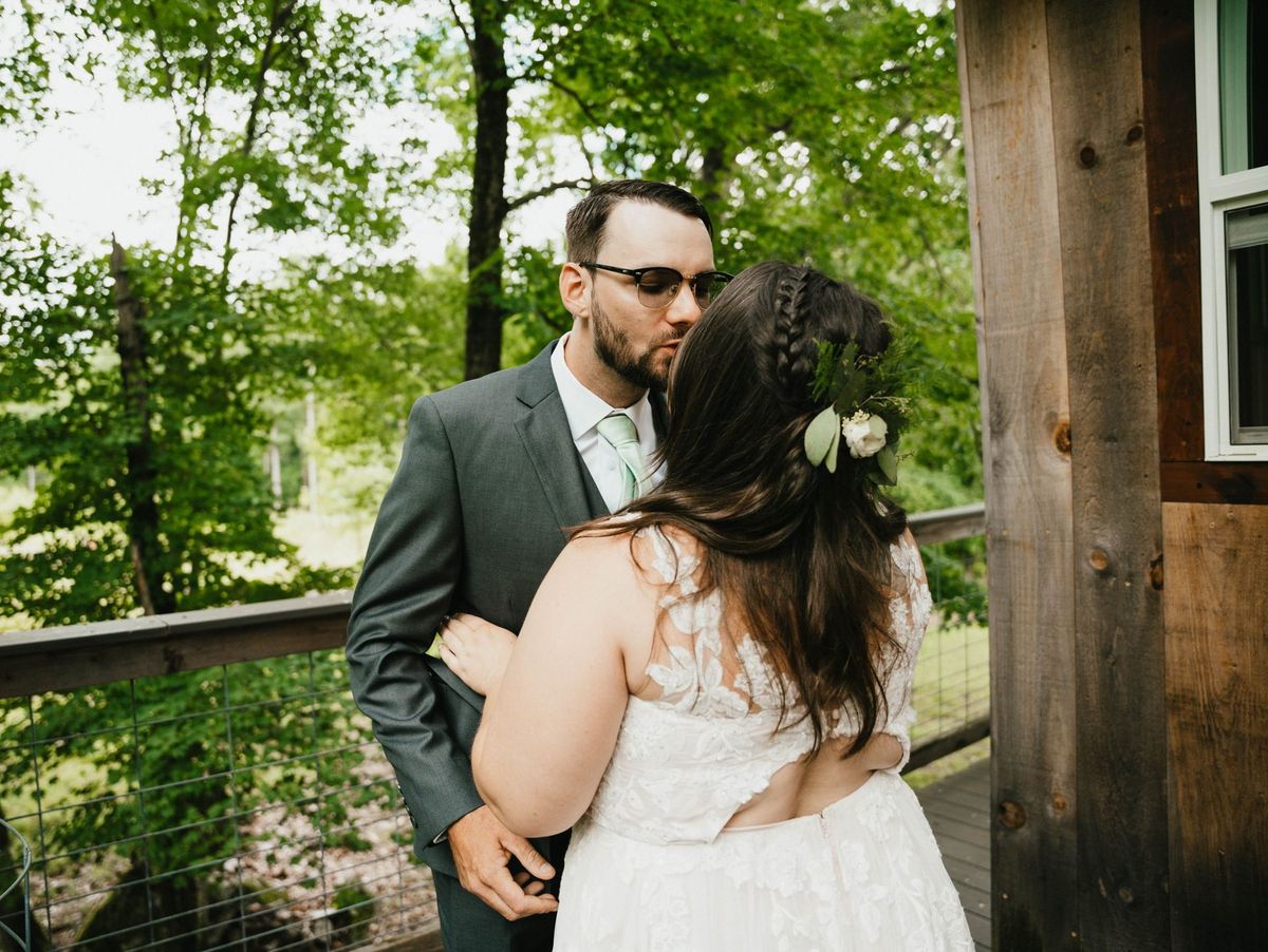 Ashley and Anthony kiss beside the deck railing