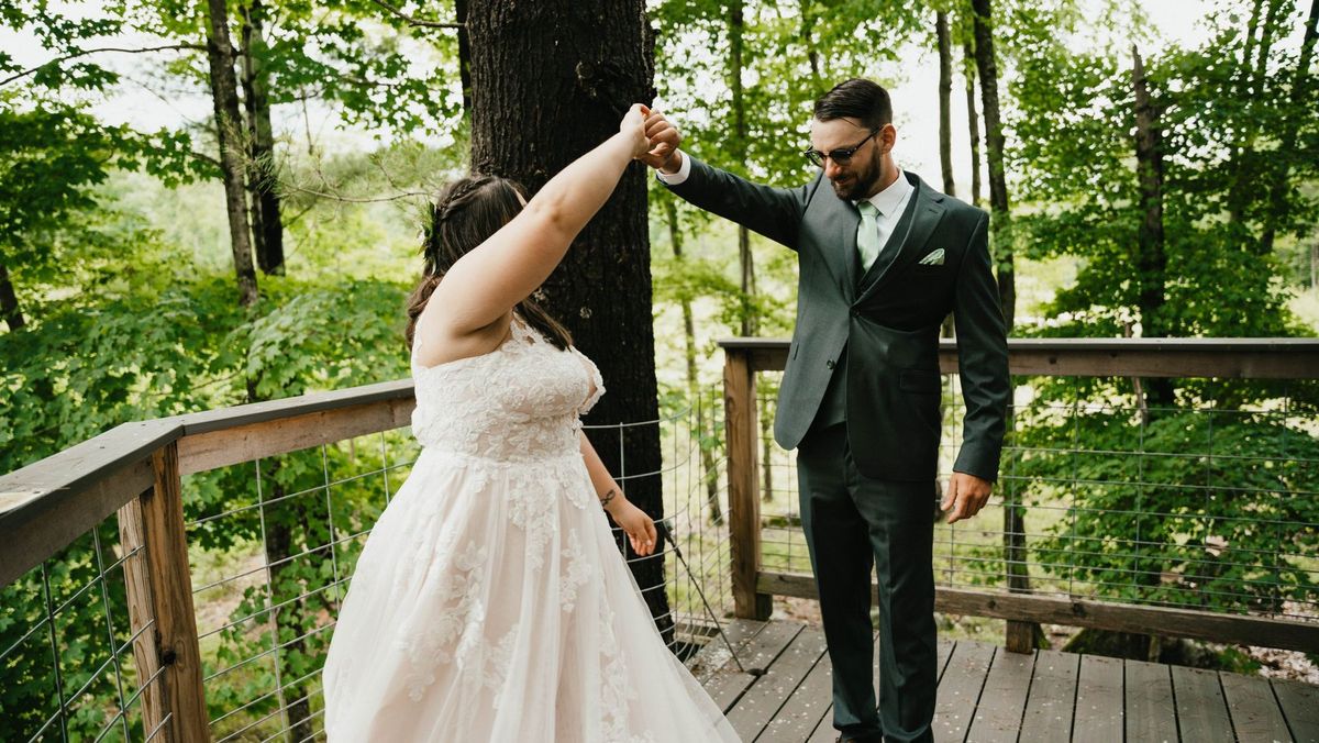 Ashley turns beneath Anthony’s raised hand on the wooded deck