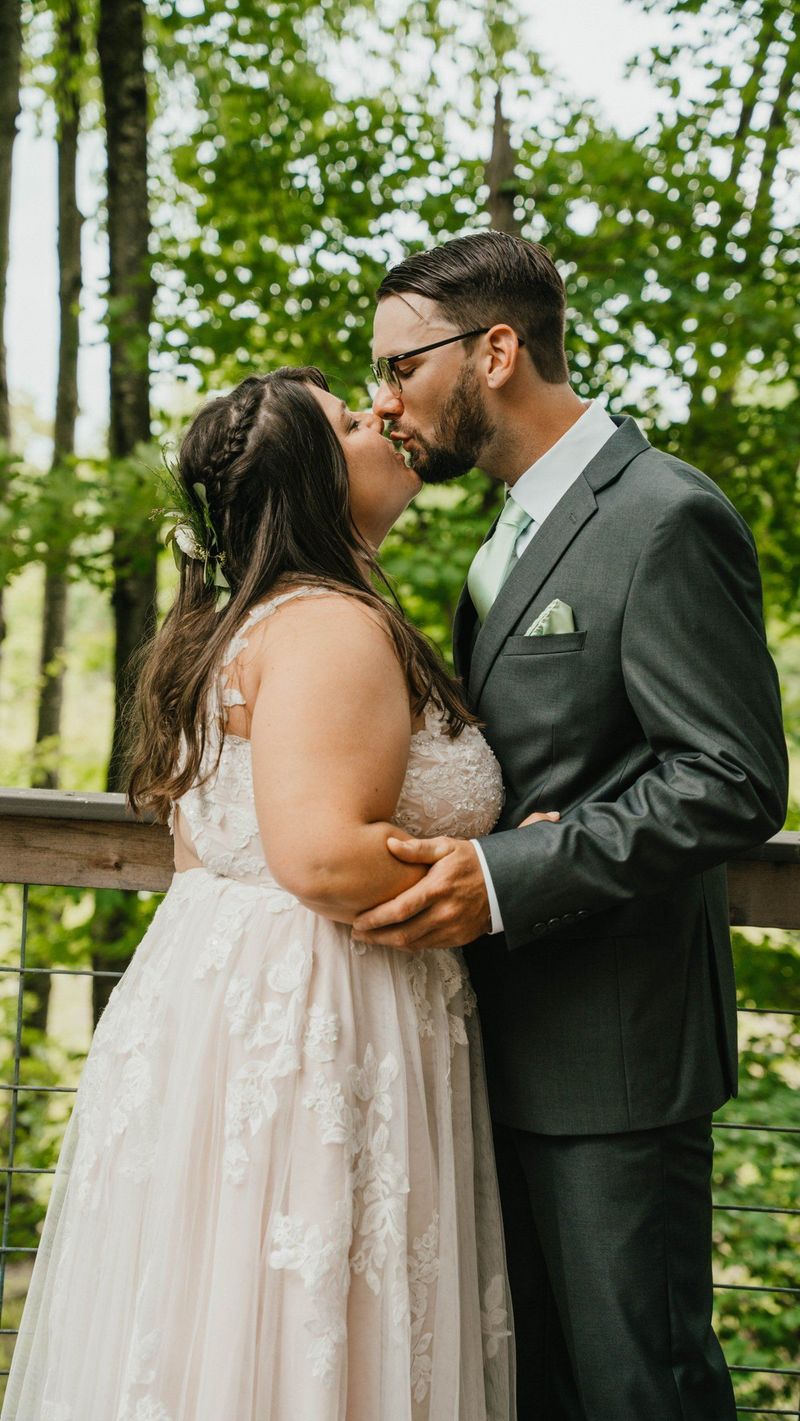 A full-length portrait of Ashley and Anthony kissing on the deck
