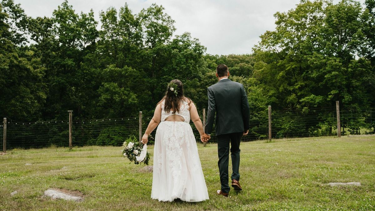 Ashley and Anthony walk hand in hand across the lawn