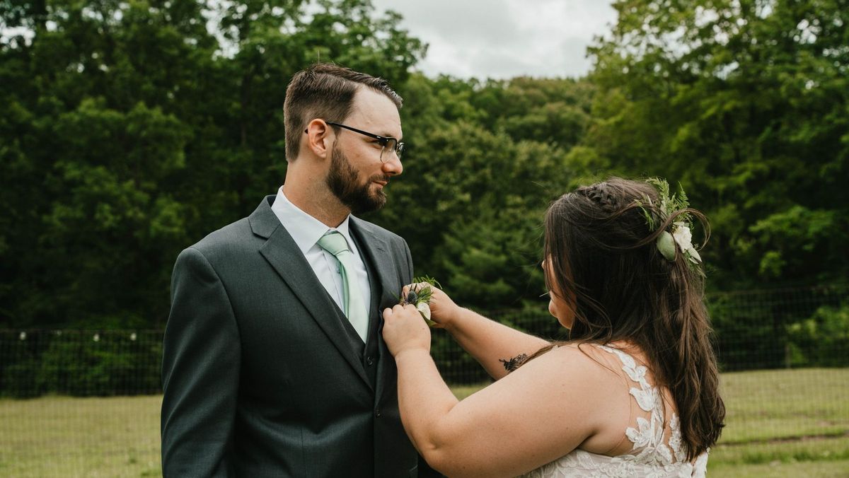 Ashley reaches toward Anthony’s lapel during their lawn portraits