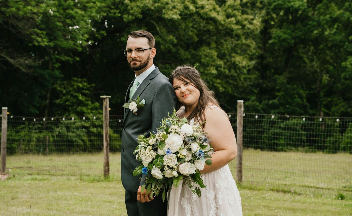 Ashley leans against Anthony with her bouquet during a couple portrait