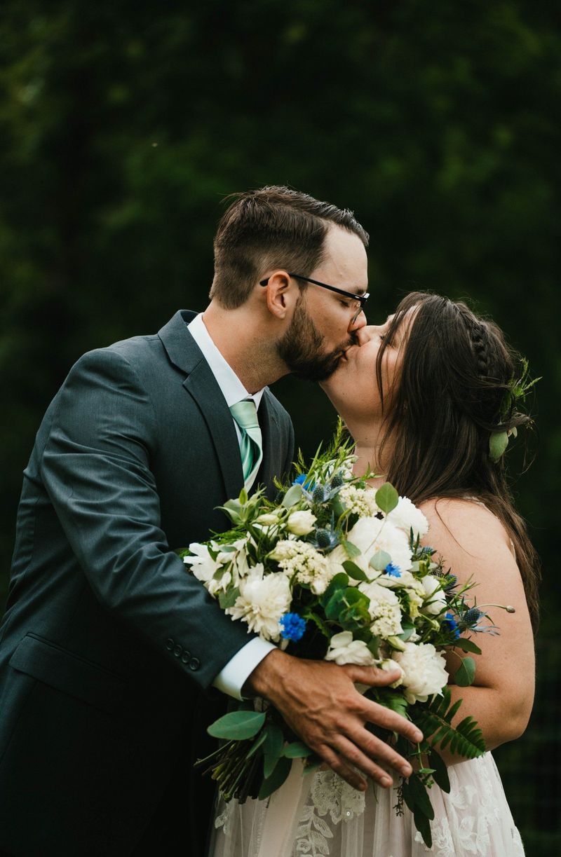 Ashley and Anthony kiss in a close lawn portrait